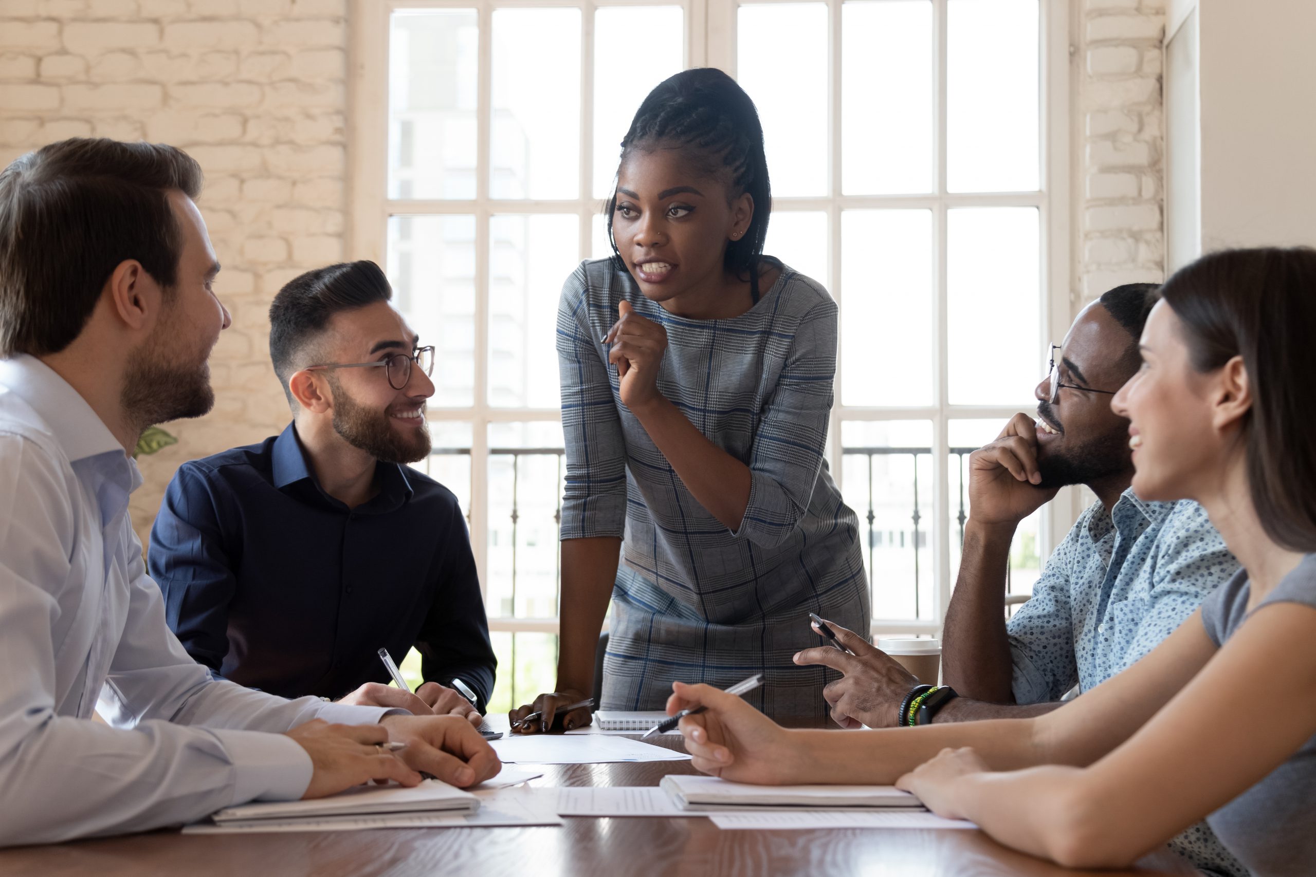 mixed culture office workers round table discussing