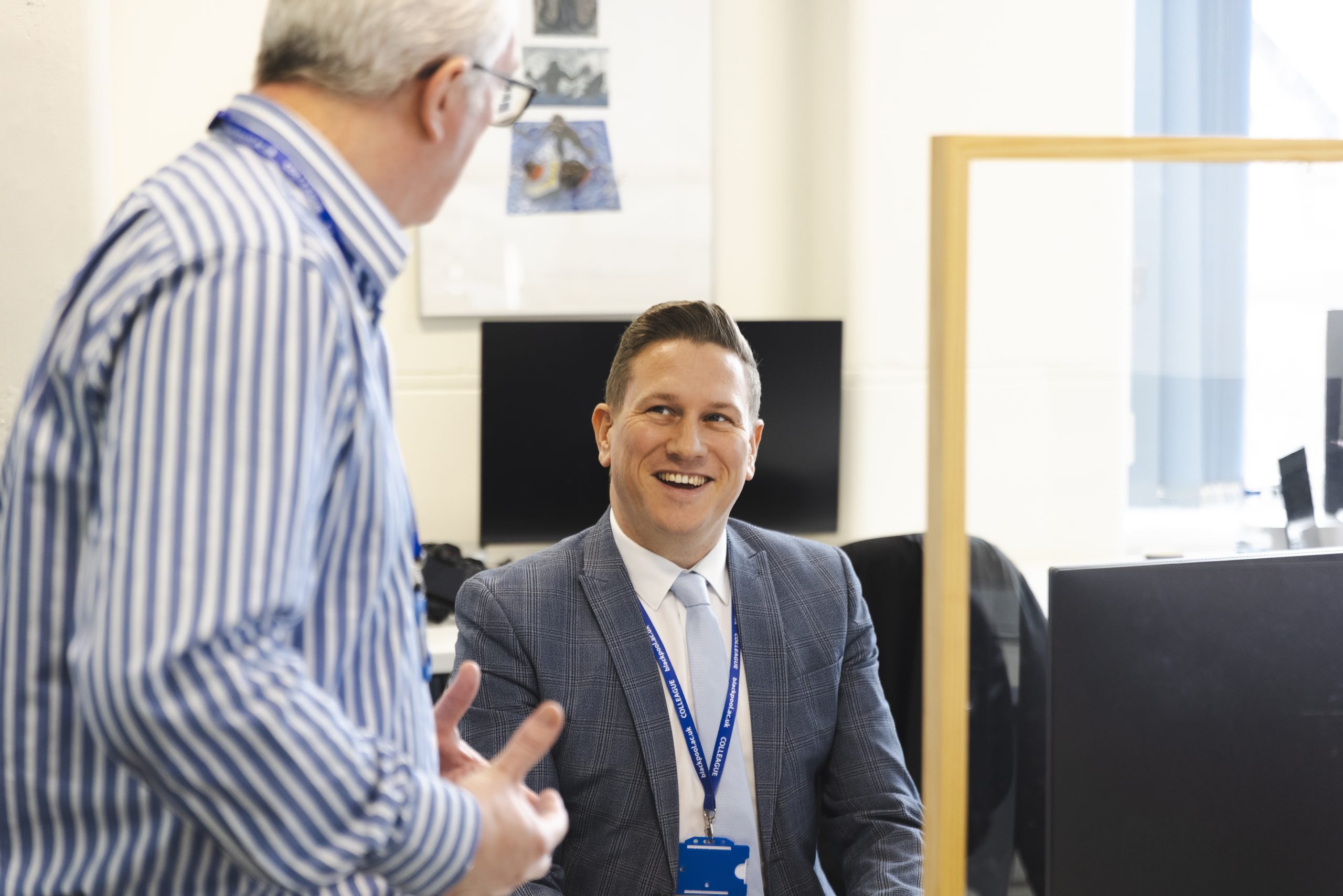 Two colleagues talking at Blackpool and Fylde College